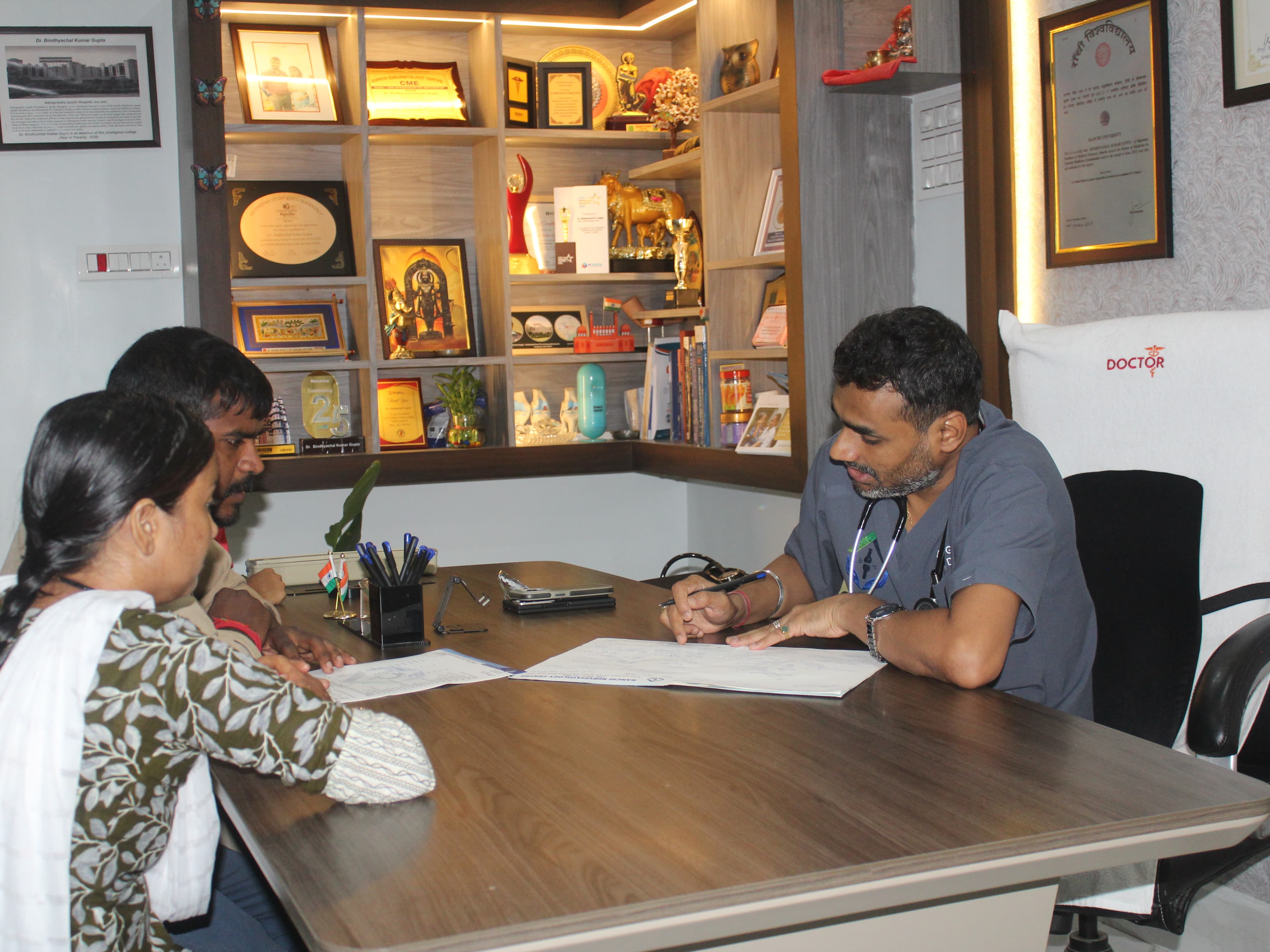 Dr. Gupta reviewing clinical notes and prescription at Ranchi Rheumatology Centre